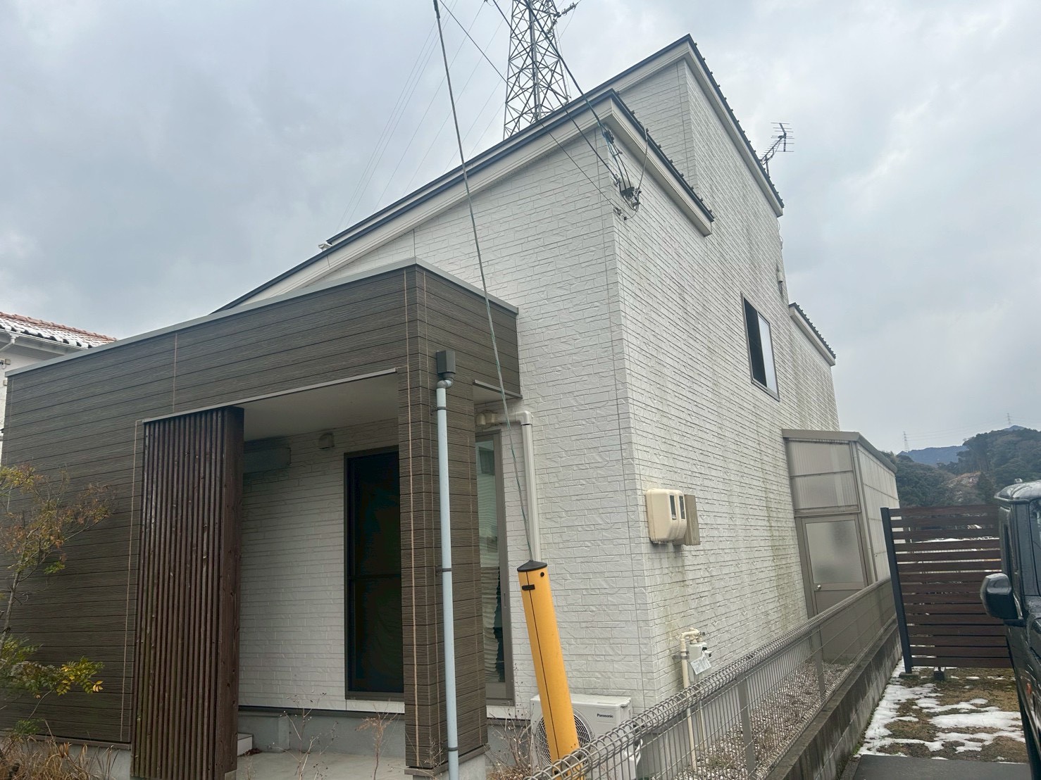 塗装前：正面から見た白い外壁と縦格子の玄関